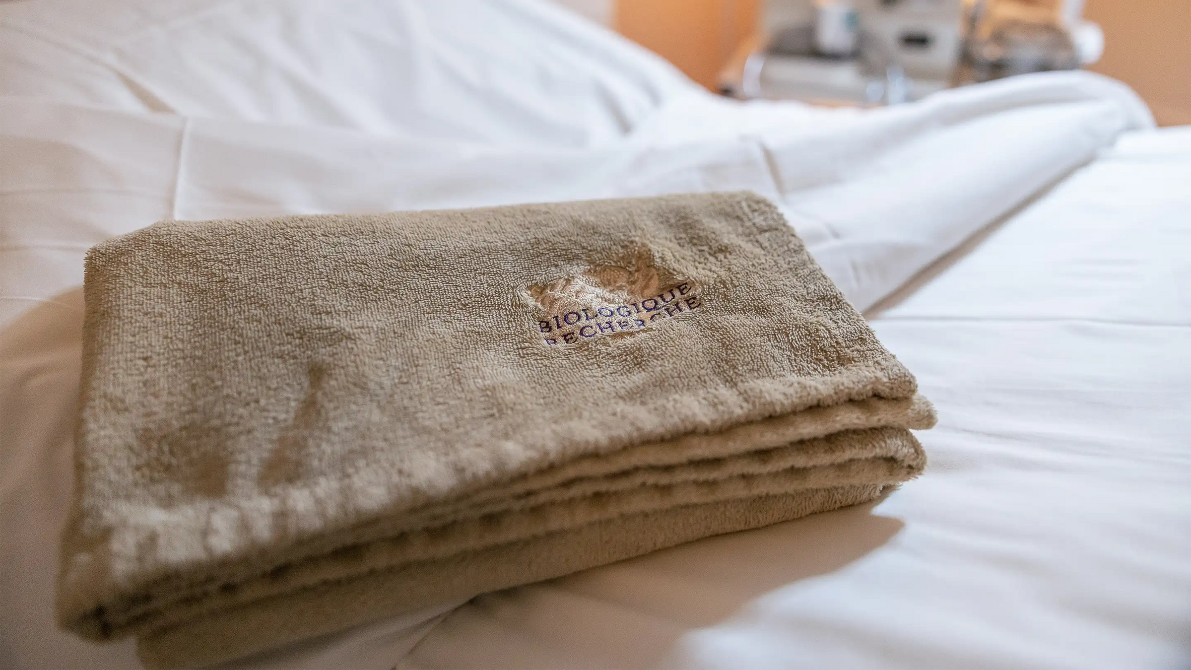 Neatly folded Biologique Recherche towel on a bed